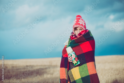 Nomad woman posing outdoor, wrapped around in a blanket