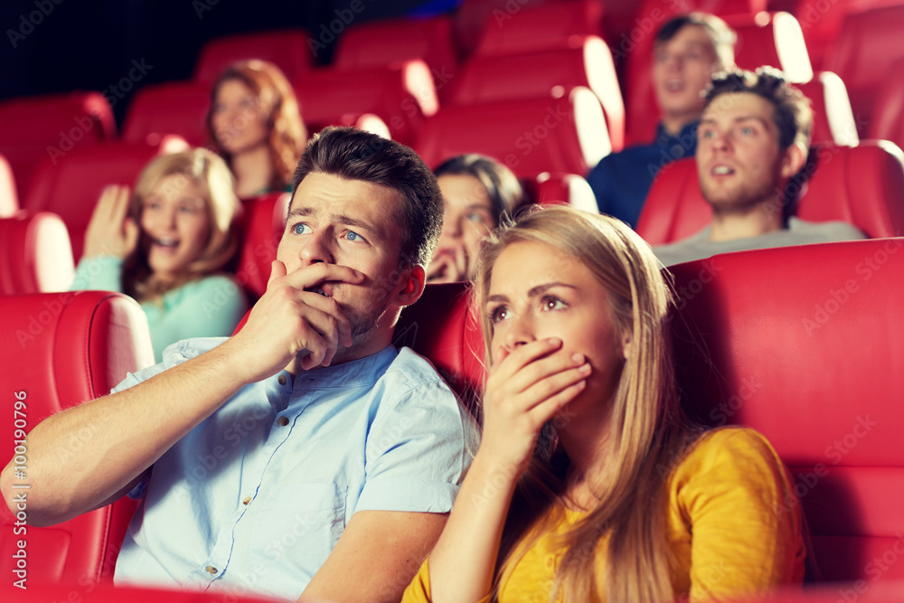Obraz premium happy friends watching horror movie in theater