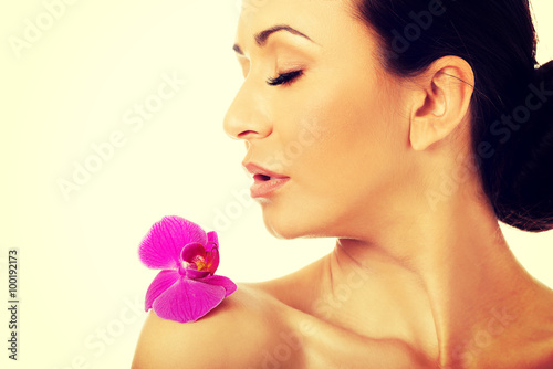 Woman with purple orchid petal on shoulder