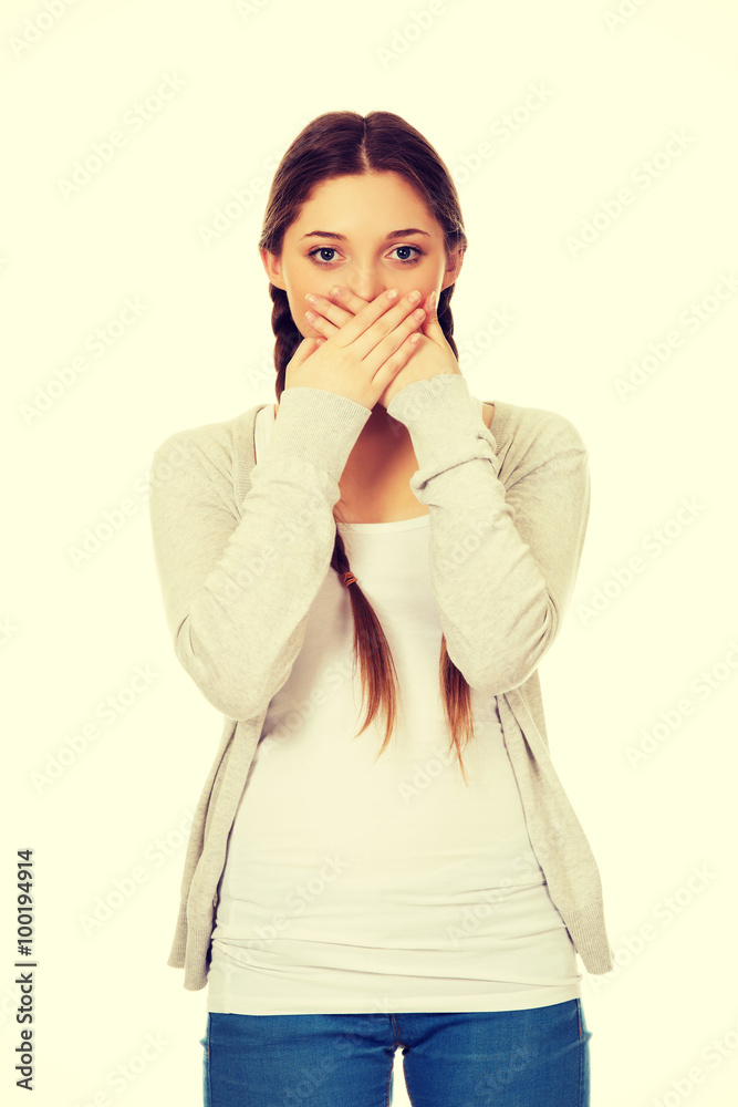 Teen woman covering her mouth.