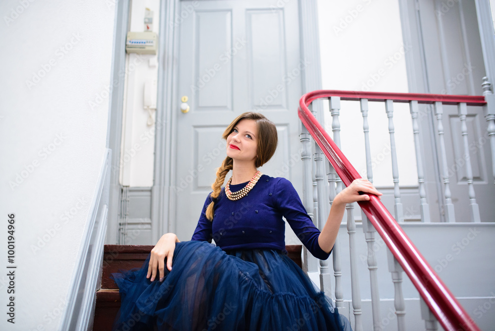 elegant woman in blue dress poses on the stairs elegant woman in blue dress poses on the stairs