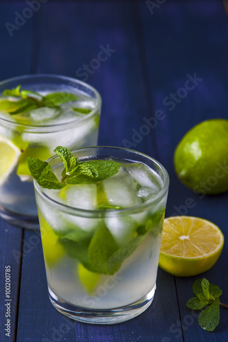 Glasses of lemonade with mint leaves and ice cubes