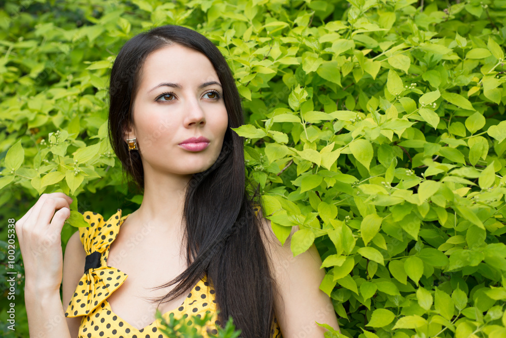 Woman standing near a tree with green leaves Woman standing near a tree with green leaves