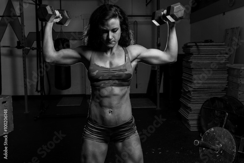 Black and white image of Woman working out in a gym with weights