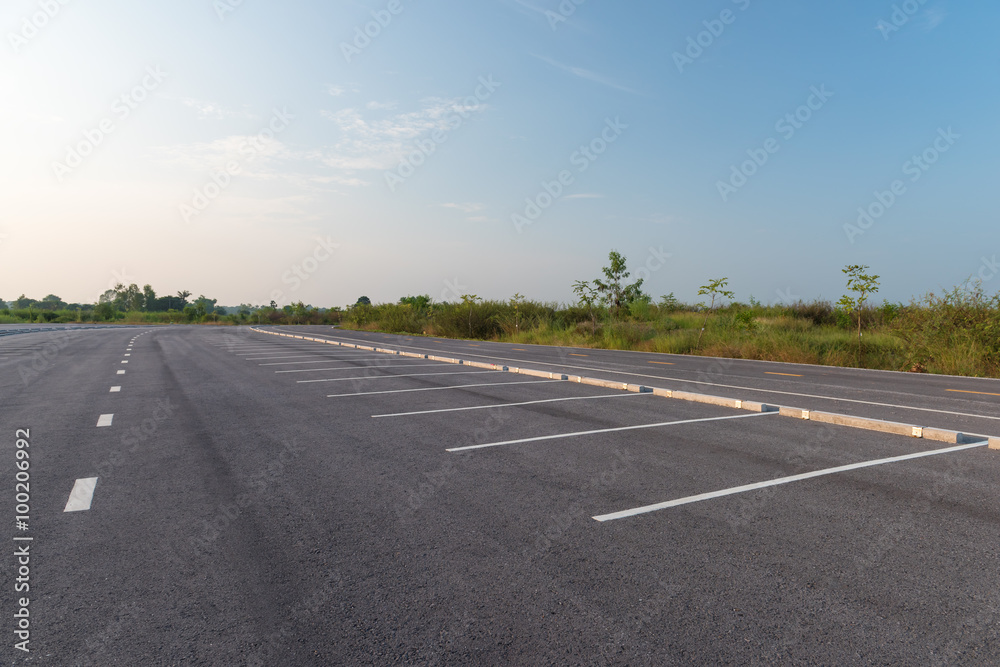 Fototapeta premium Empty parking lot against a beautiful blue sky