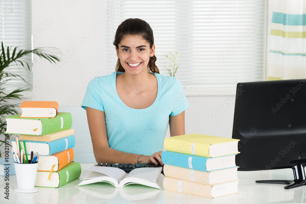 Female Student Using Computer While Studying At Table Female Student Using Computer While Studying At Table