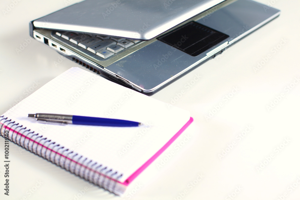 Office table with blank notepad and laptop Office table with blank notepad and laptop