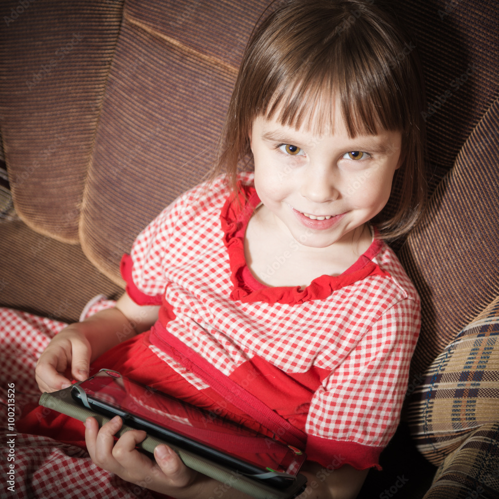 Little girl playing with a modern digital tablet. Little girl playing with a modern digital tablet.