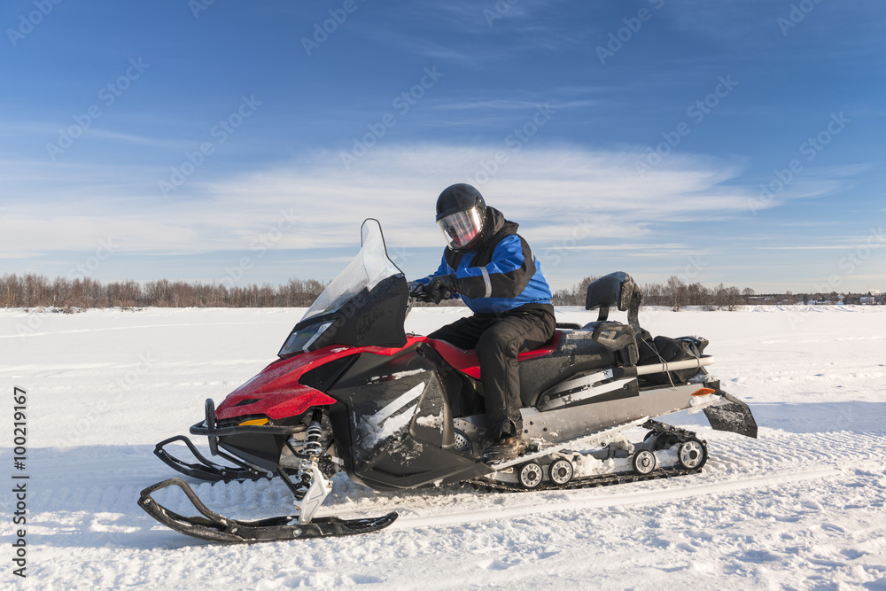 Man driving snowmobile in snowy field