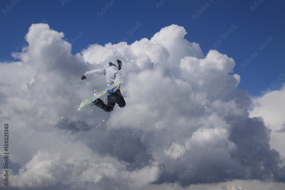 Flying snowboarder on mountains. Extreme sport.