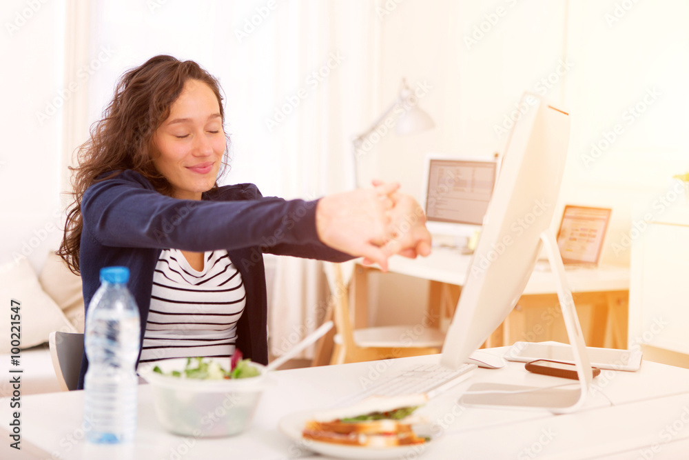 Young attractive student eating while working