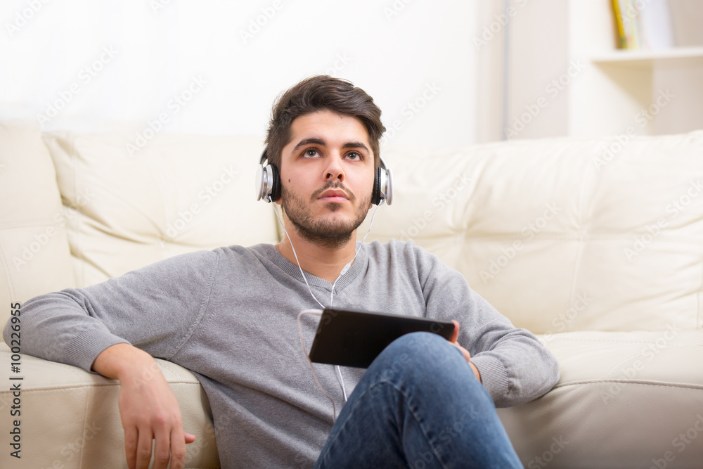 Handsome casual young man using a tablet at home