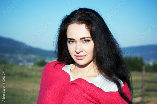 portrait of a girl looking at camera on the mountains background