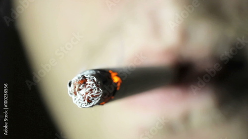 Young guy smokes cigarette closeup