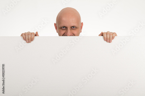 Bald man peeps over top of blank white paper