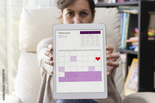 Woman holding tablet with Valentine's Day diary