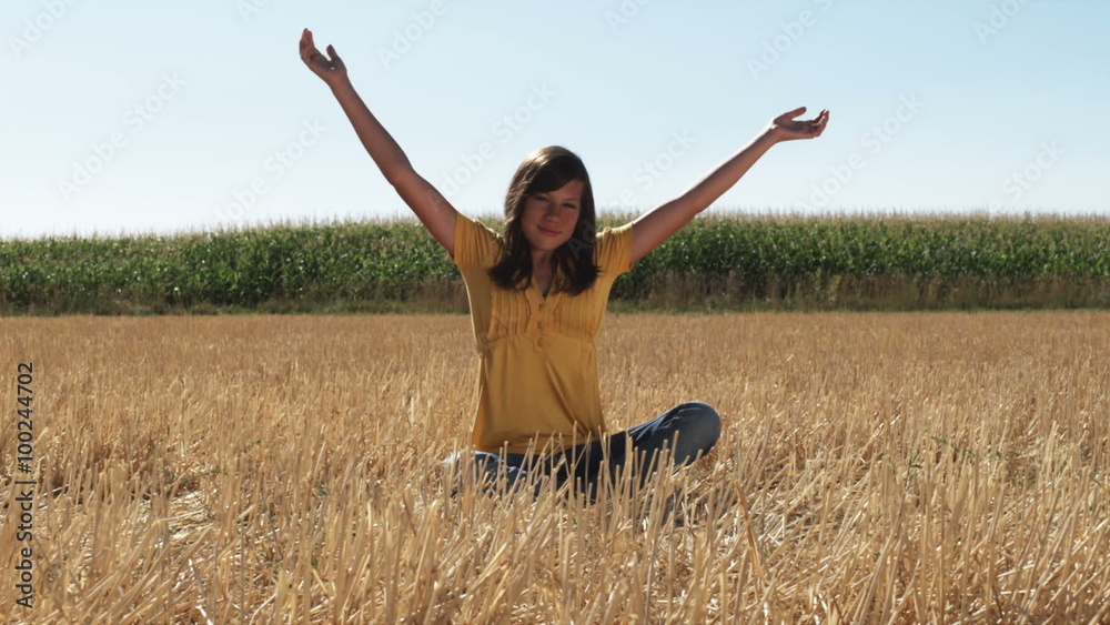 Dark haired woman meditating in a wheat field Dark haired woman meditating in a wheat field