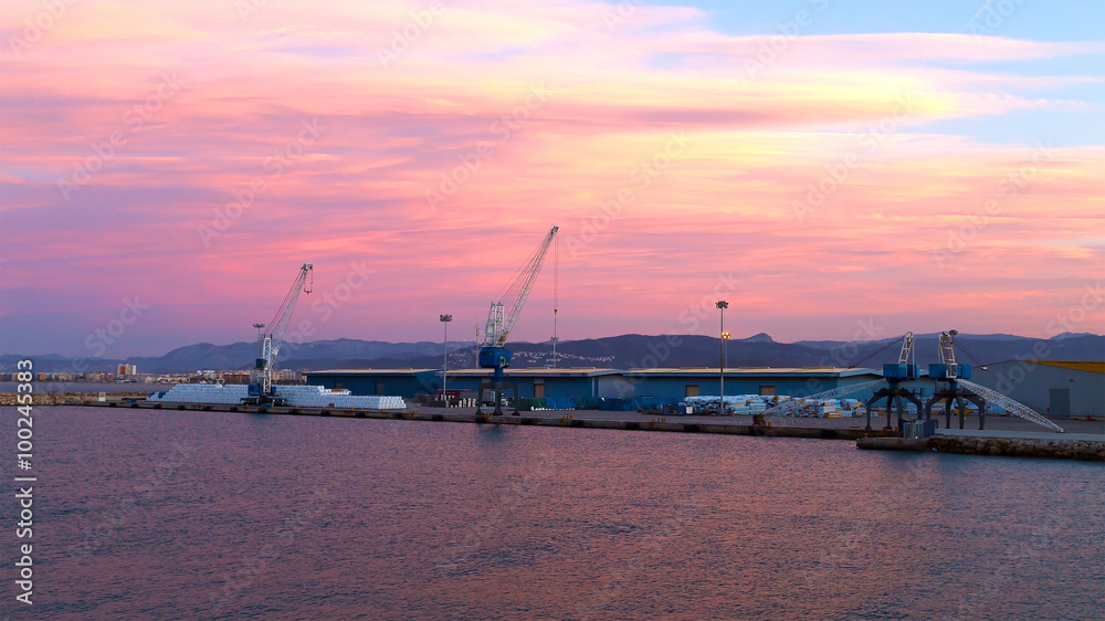 Sea port at sunset. Soft sunset colors illuminate small port and calm harbour near Valencia, Spain.