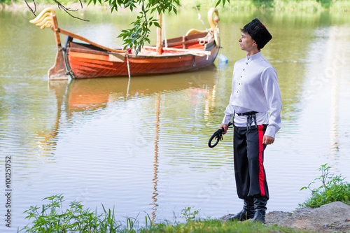 man wearing a stylized Ukrainian costumes posing with whip photo