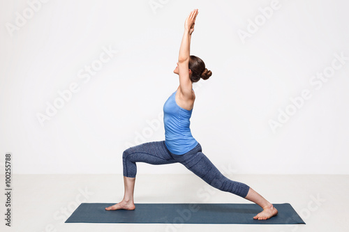 Sporty fit yogini woman practices yoga asana utthita Virabhadras