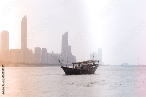 Abu Dhabi buildings skyline with old fishing boat