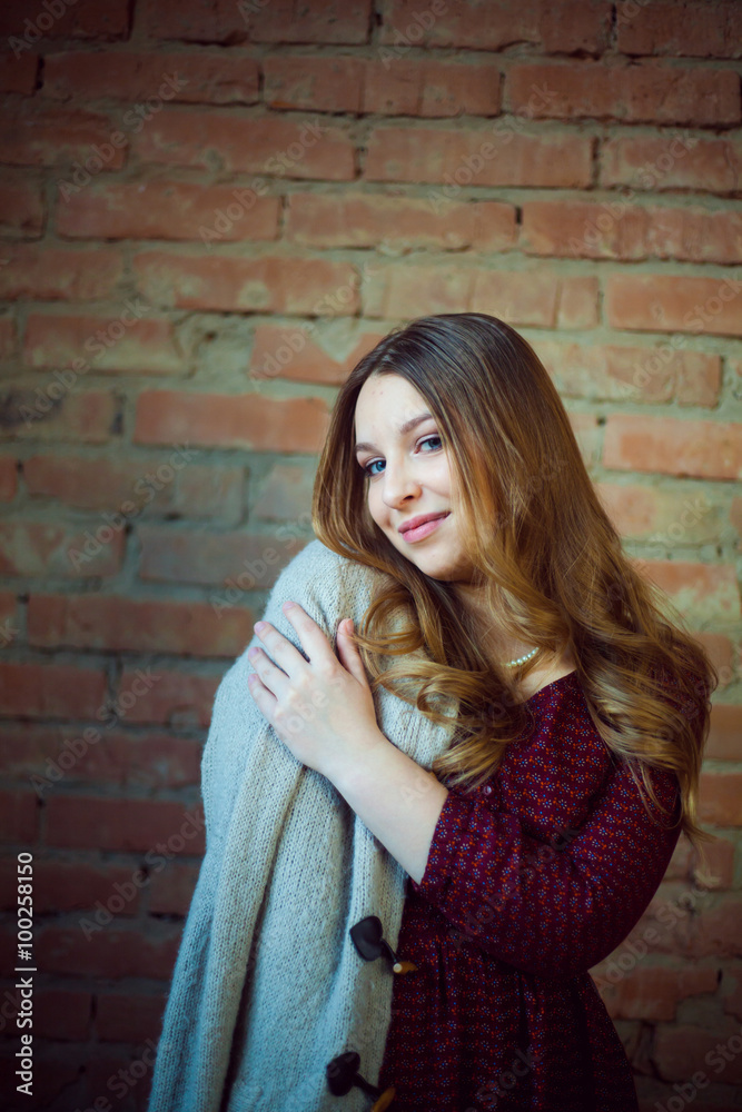 beautiful girl portrait white sweater brick background