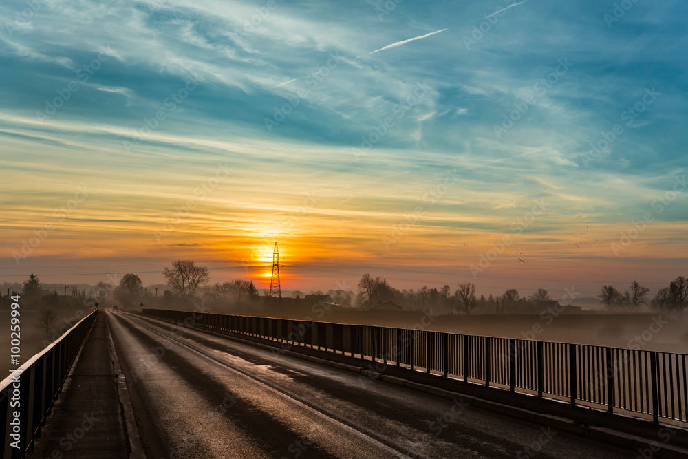 Fototapeta premium Wschód słońca widziany z mostu na rzece Warta