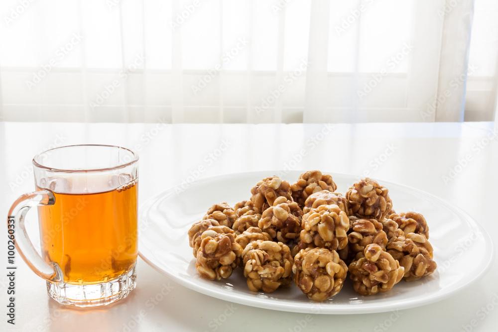 Sweet peanut balls in a plate and glass of black tea Sweet peanut balls in a plate and glass of black tea