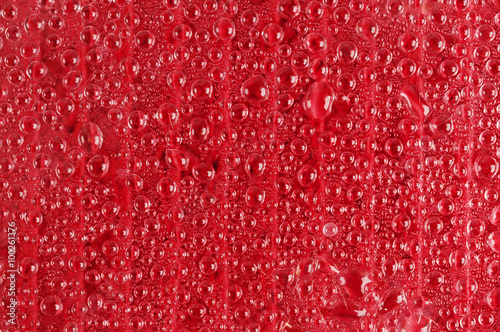 Water drops on red transparent glass