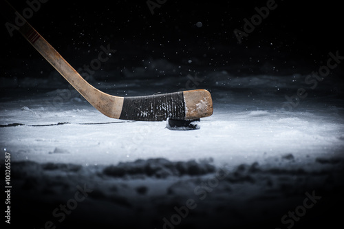 Hockey stick and puck on ice photo