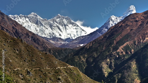 Time-lapse of the tip of Everest and surrounding peaks and trekkers on a foreground trail.  photo