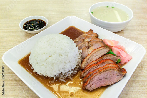 Roasted Duck and Red Pork with Rice on White Square Plate Served with Sauce and Soup on Wooden Table