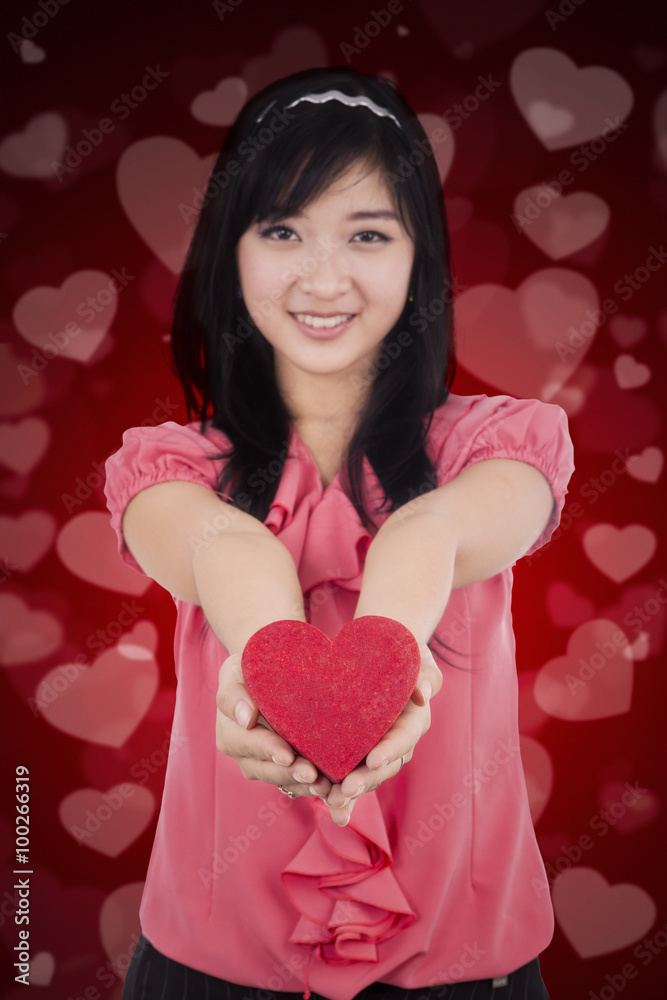 Chinese girl holds a gift with heart background Chinese girl holds a gift with heart background