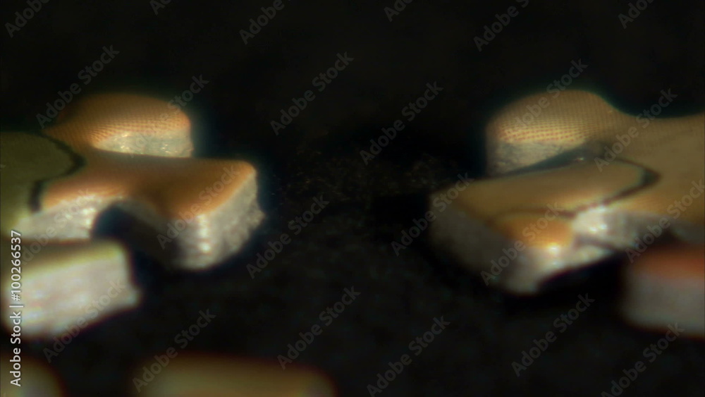 Close up pan of puzzle pieces on a black surface. Close up pan of puzzle pieces on a black surface.