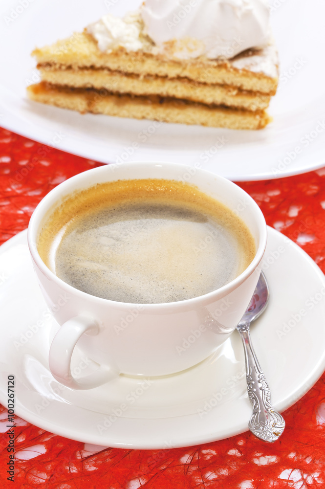 A cup of coffee and a slice of cake on the background of sisal