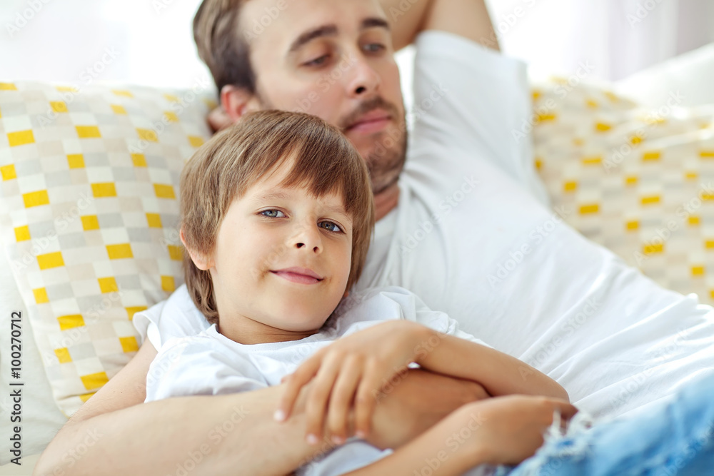 Happy father with son lying on the sofa Happy father with son lying on the sofa