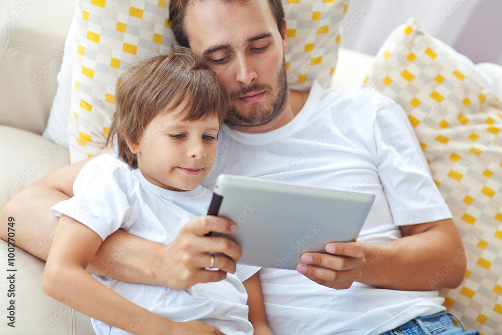 Happy father with son are playing on gadget Happy father with son are playing on gadget