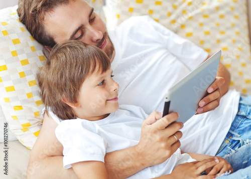 Happy father with son are playing on gadget  photo