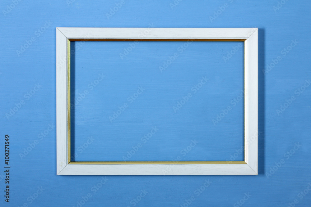 white wooden photo frame with gold inlay on a blue background white wooden photo frame with gold inlay on a blue background