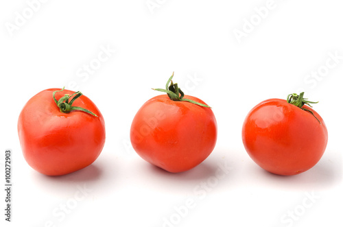 Three fresh tomato in row isolated on white