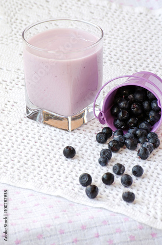 Blueberry yogurt in a glass and blueberries