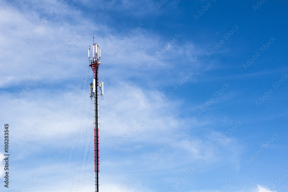 Red and white tower of communications with antennas under blue sky and clouds Red and white tower of communications with antennas under blue sky and clouds