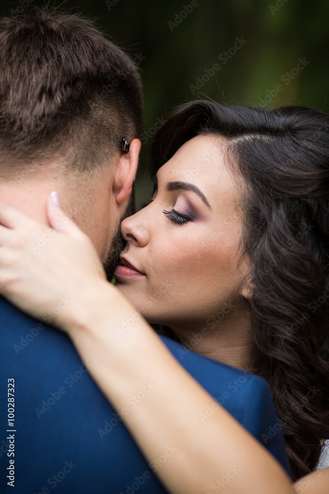 Closeup of a beautiful, happy bride hugging handsome groom with Closeup of a beautiful, happy bride hugging handsome groom with