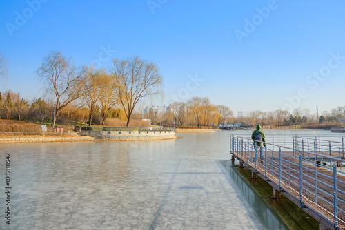 The man on the walk way at the frozen lake. © nattapan72