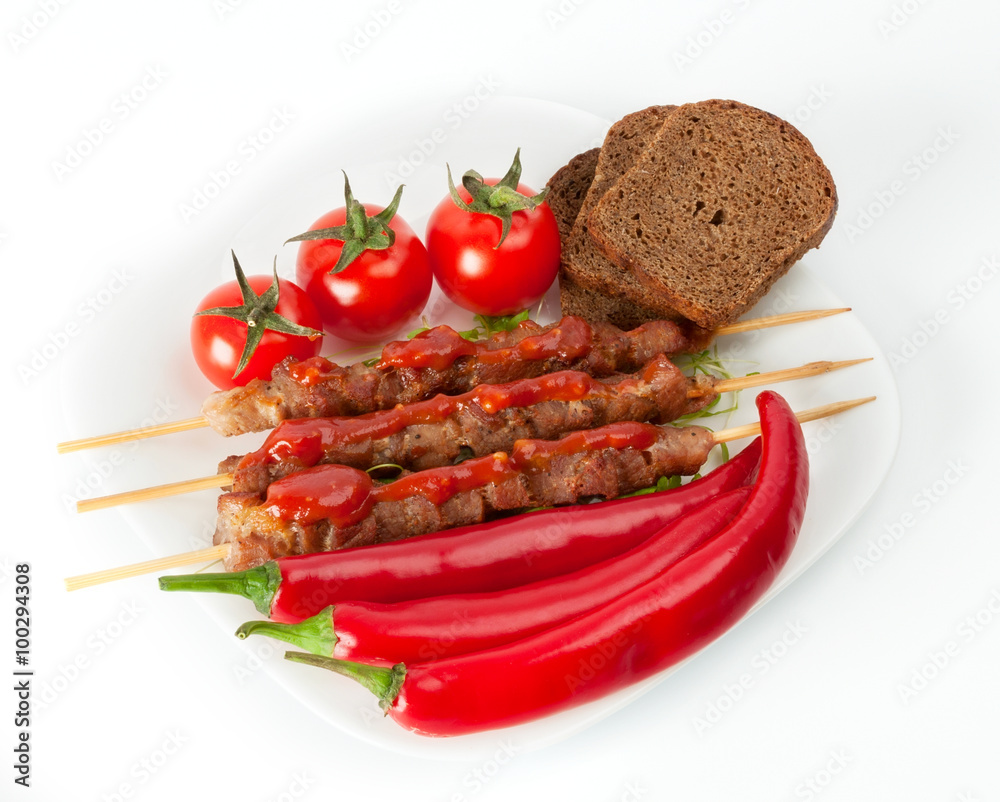 Shish kebab with herbs on a white plate Shish kebab with herbs on a white plate
