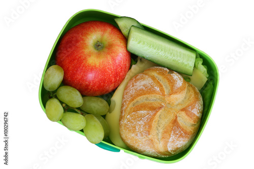Lunch box with cheese roll, apple, grapes and cucumbers sticks isolated on white
