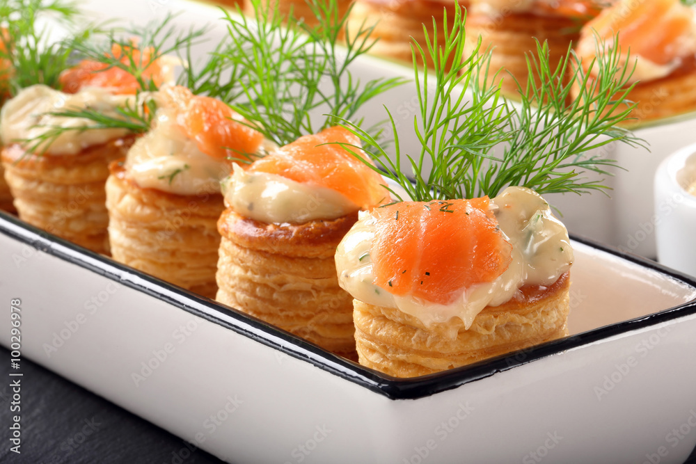 Appetizer puff pastry with dill dip and salmon on stone tray Appetizer puff pastry with dill dip and salmon on stone tray