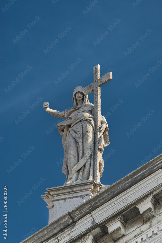Statue of Saint with cross at San Stae catholic Church in Venice