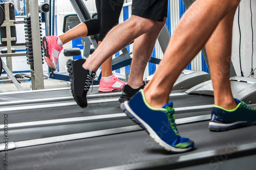 Group of legs wearing sneakers running on treadmill  at sport gym. © Gennadiy Poznyakov