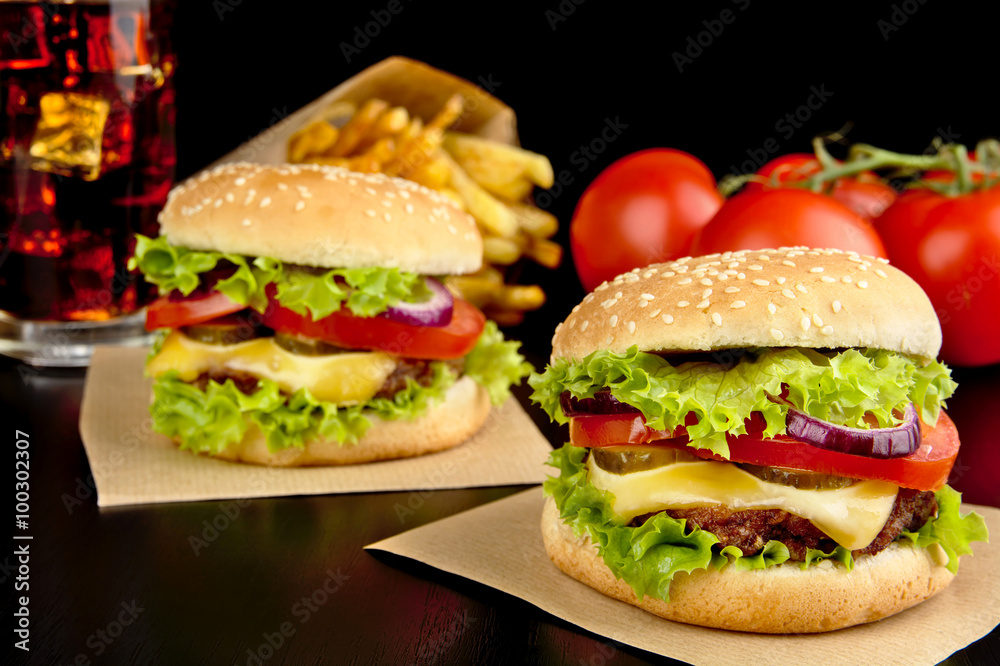 Cheeseburgers,french fries on wooden desk on black Cheeseburgers,french fries on wooden desk on black
